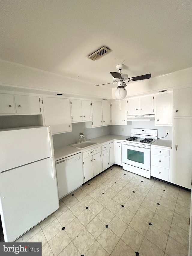 kitchen featuring visible vents, white cabinets, a sink, white appliances, and under cabinet range hood