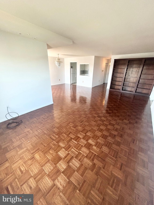 unfurnished living room with an inviting chandelier