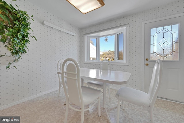 dining room featuring baseboards and wallpapered walls