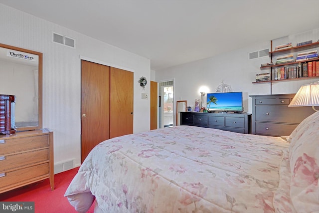 carpeted bedroom with visible vents and a closet