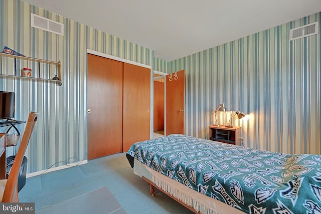 carpeted bedroom with a closet, visible vents, and wallpapered walls