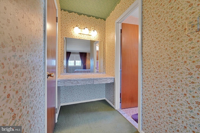 bathroom with baseboards and wallpapered walls