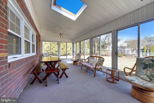 sunroom featuring vaulted ceiling with skylight