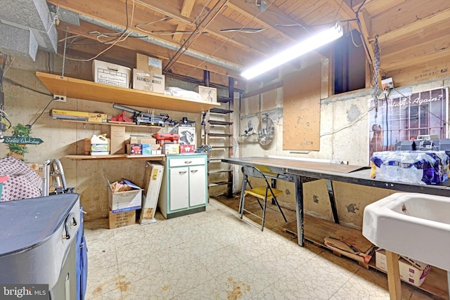 below grade area featuring tile patterned floors, a workshop area, and a sink