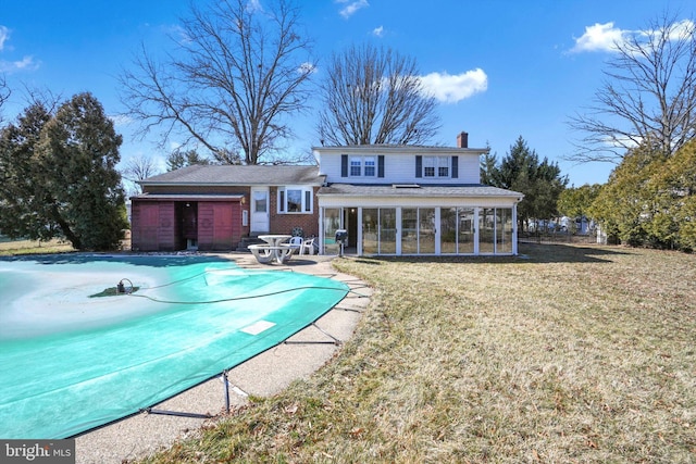 view of pool with a covered pool, a lawn, a patio, and a sunroom