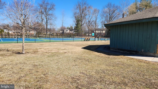 view of yard with a tennis court and fence