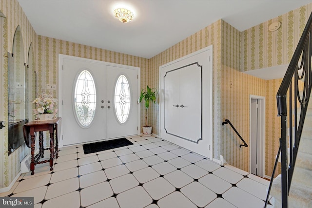 entrance foyer with tile patterned floors and wallpapered walls