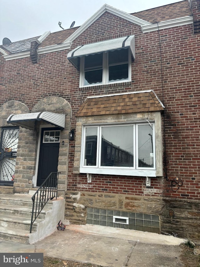 view of front facade featuring stone siding and brick siding