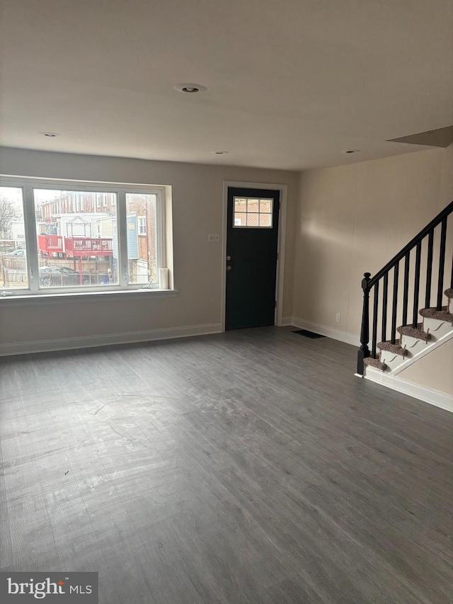 foyer with stairway, wood finished floors, and baseboards