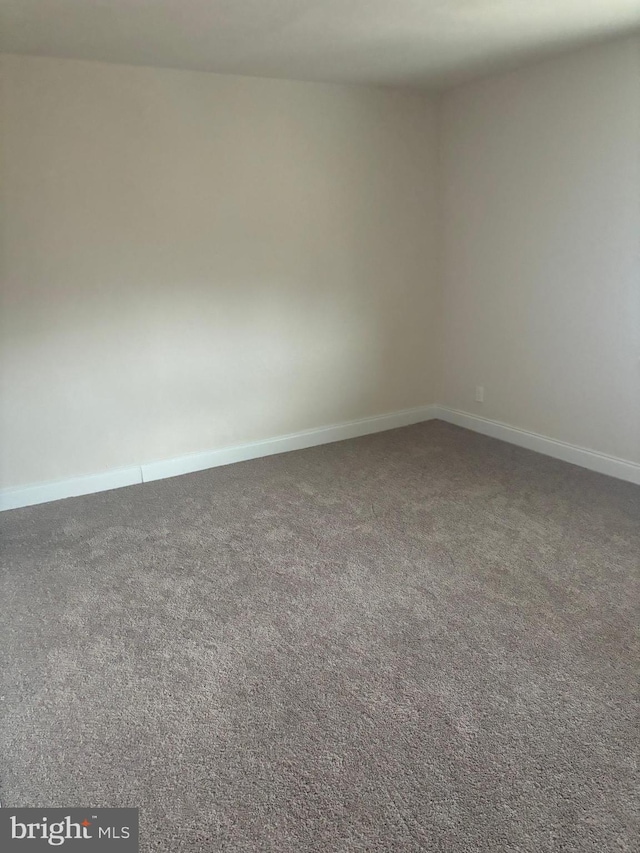 unfurnished room with carpet flooring and baseboards