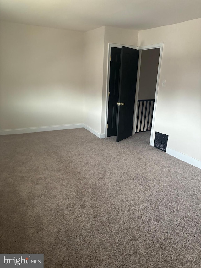 carpeted empty room featuring baseboards