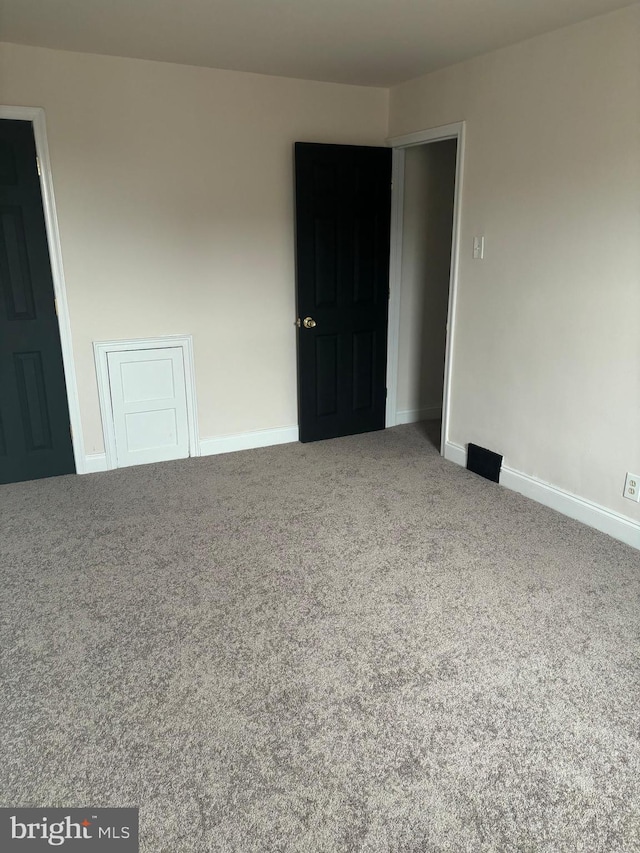 unfurnished room with carpet and baseboards