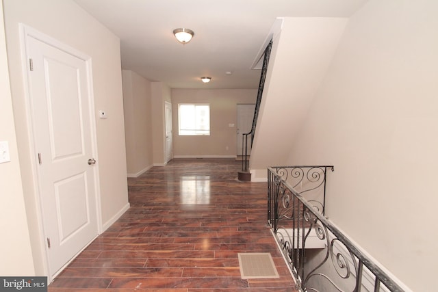 corridor with stairs, baseboards, visible vents, and dark wood-style flooring