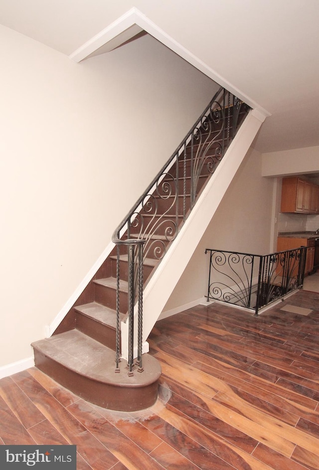 stairs featuring wood finished floors and baseboards