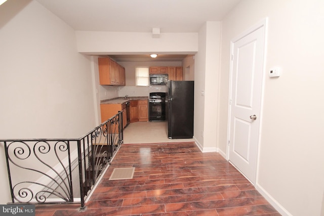 kitchen with wood finished floors, visible vents, freestanding refrigerator, decorative backsplash, and gas range