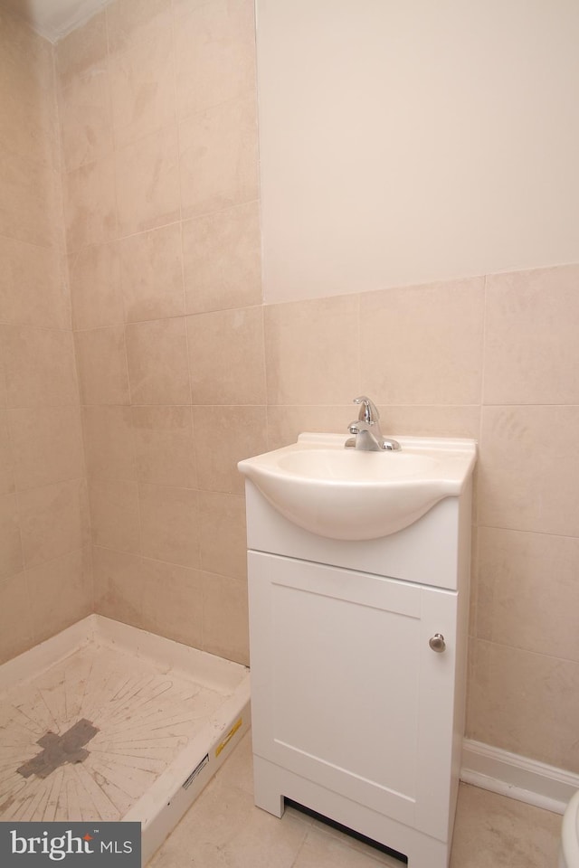 full bath featuring tile walls, a shower stall, and vanity