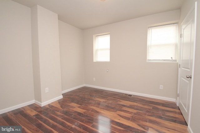 empty room featuring dark wood-style floors and baseboards