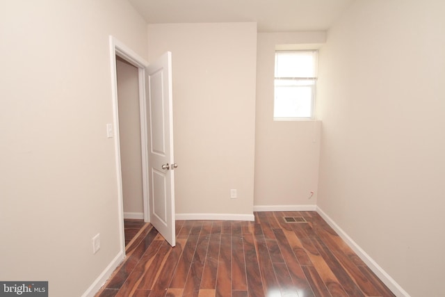 interior space featuring dark wood-type flooring and baseboards