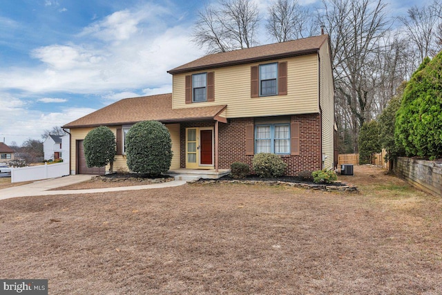 view of front of property with a garage, driveway, brick siding, and fence