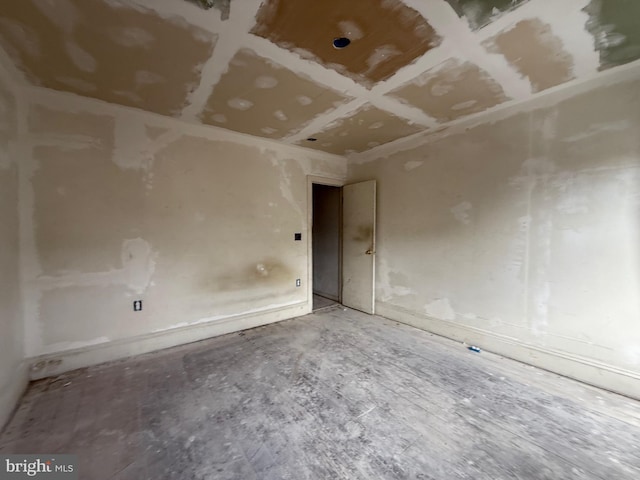 unfurnished room featuring coffered ceiling