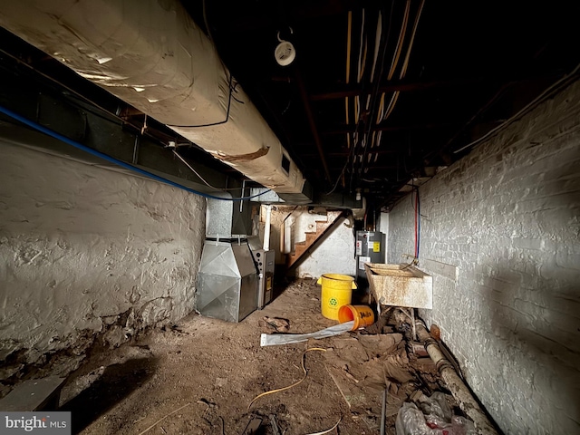 interior space with heating unit, electric water heater, and stairs