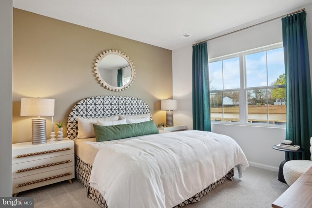 carpeted bedroom featuring visible vents and baseboards