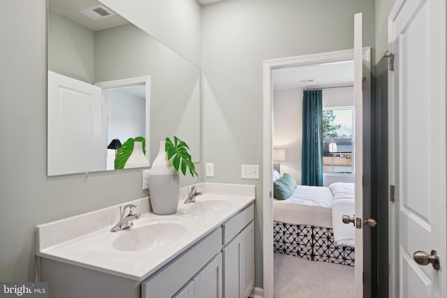 bathroom with visible vents, a sink, ensuite bathroom, and double vanity