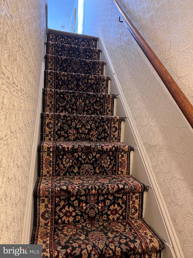 stairway featuring wallpapered walls