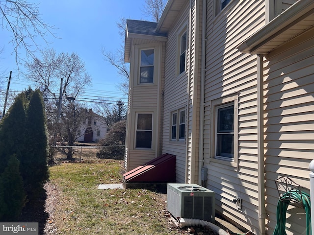 view of side of property with fence and central AC unit