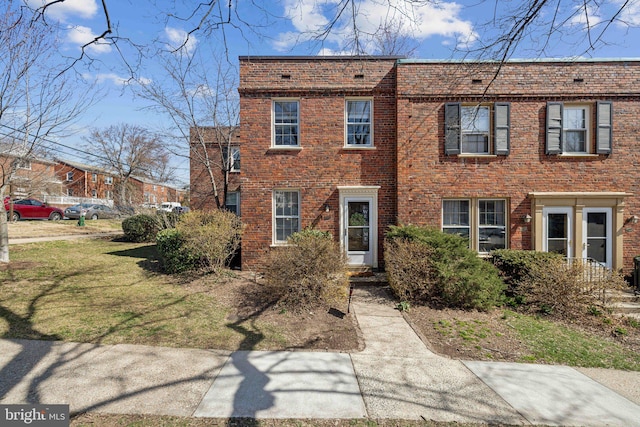 view of front of house with brick siding and a front lawn