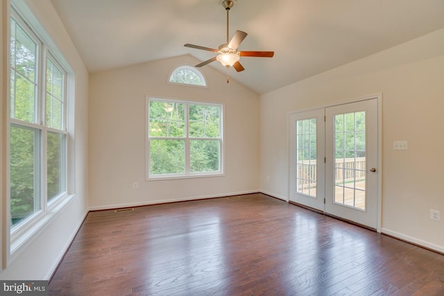 empty room with lofted ceiling, a wealth of natural light, ceiling fan, and dark wood finished floors
