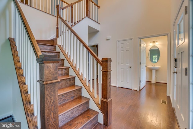 entryway featuring baseboards, a high ceiling, stairway, and hardwood / wood-style floors