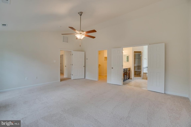 unfurnished bedroom featuring ensuite bathroom, high vaulted ceiling, visible vents, baseboards, and light colored carpet