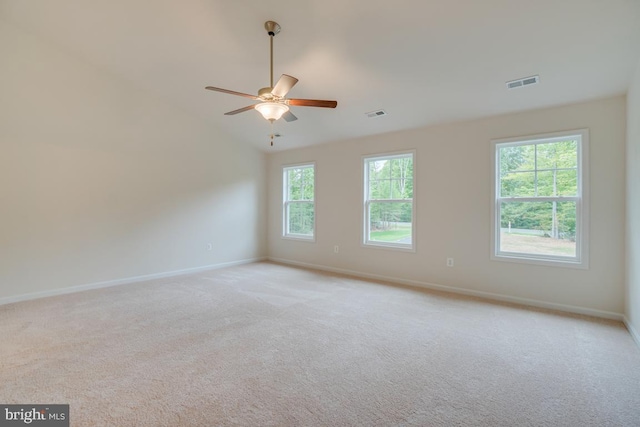 empty room with visible vents, light carpet, baseboards, and ceiling fan