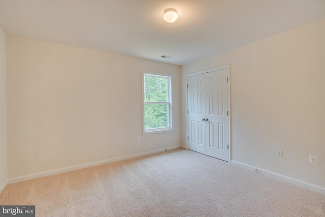 unfurnished bedroom with baseboards, visible vents, a closet, and carpet flooring