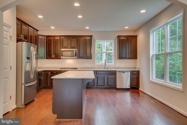 kitchen featuring light countertops, a sink, stainless steel appliances, and wood finished floors