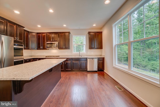 kitchen with recessed lighting, stainless steel appliances, dark wood-style floors, visible vents, and dark brown cabinetry