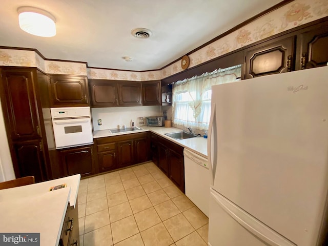 kitchen featuring light countertops, white appliances, visible vents, and a sink