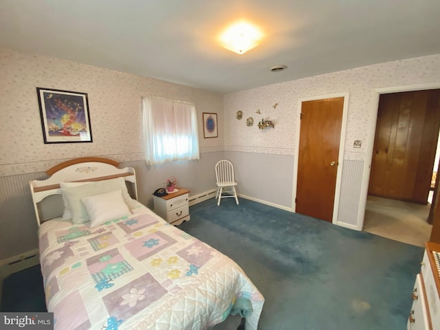 bedroom with wallpapered walls, dark carpet, a wainscoted wall, and a baseboard heating unit