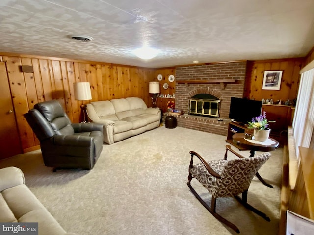 living room with a fireplace, carpet flooring, visible vents, and wooden walls