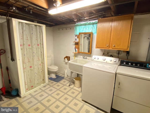 laundry area with cabinet space, a sink, washer and clothes dryer, and light floors