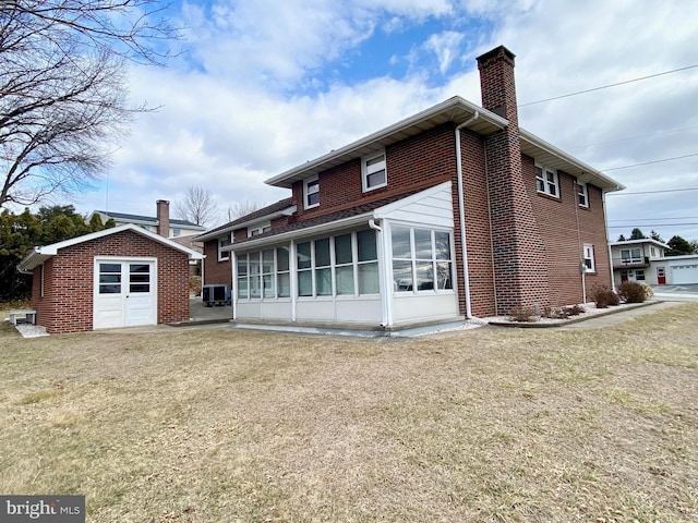 back of property featuring brick siding, a chimney, central AC unit, and an outdoor structure