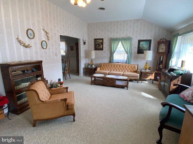 carpeted living room featuring lofted ceiling, visible vents, and wallpapered walls