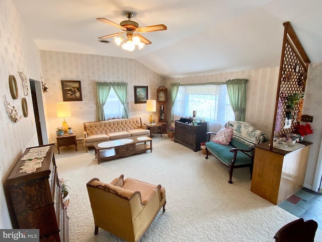 carpeted living area with wallpapered walls, ceiling fan, and vaulted ceiling