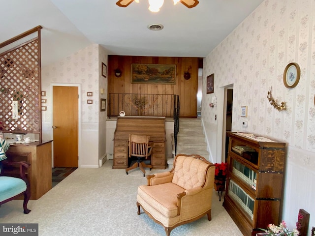 sitting room with carpet floors, visible vents, stairs, and wallpapered walls