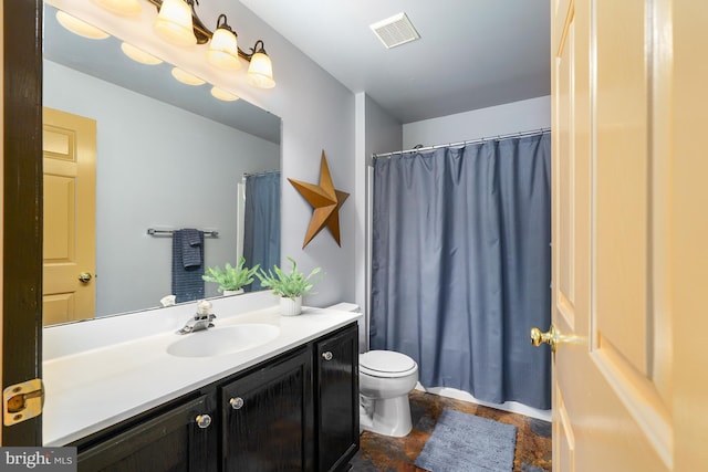 bathroom featuring visible vents, a shower with shower curtain, toilet, stone finish floor, and vanity