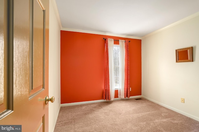 unfurnished room featuring carpet, visible vents, baseboards, and crown molding