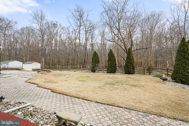 view of yard with an outbuilding, a fenced backyard, and a storage unit