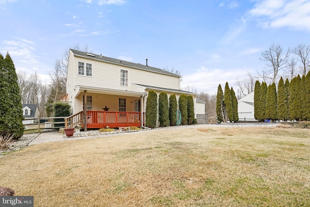 back of property featuring a lawn and a deck