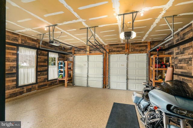 garage with wood walls and a garage door opener